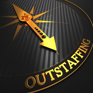Outstaffing - Business Concept. Golden Compass Needle on a Black Field Pointing to the Word 