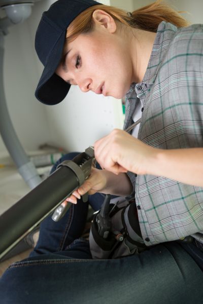 a woman preparing caulk gun